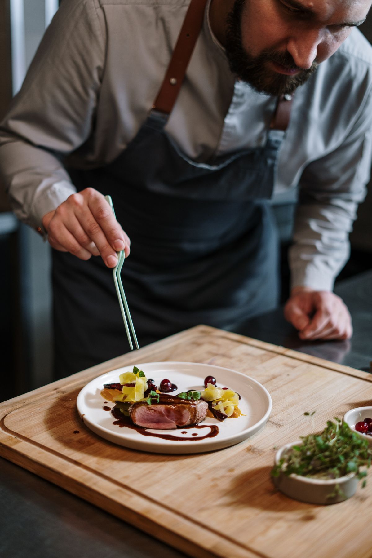 Virėjas dėlioja patiekalą Druska bistro virtuvėje